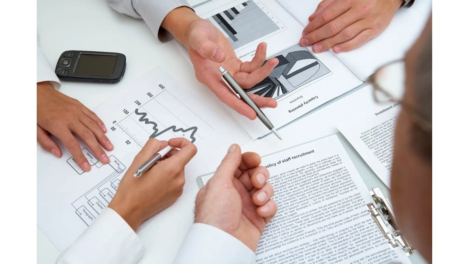 Colleagues reviewing charts and documents around a table