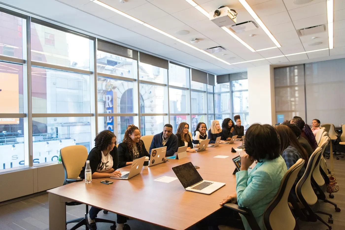 A team working around a conference table with laptops