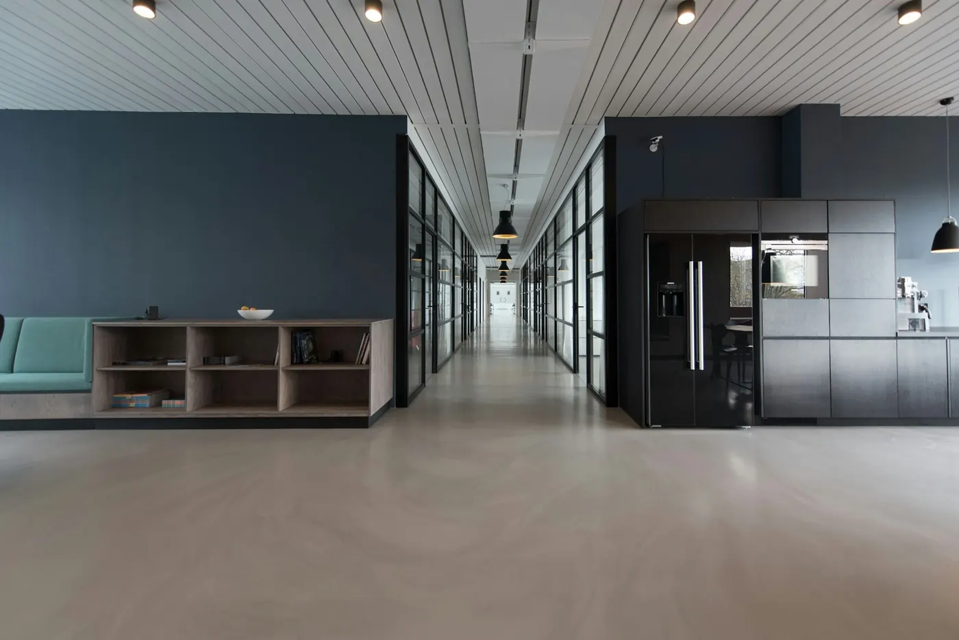 A modern glass-walled office corridor